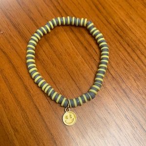 Clay head brace with metal smiley face charm